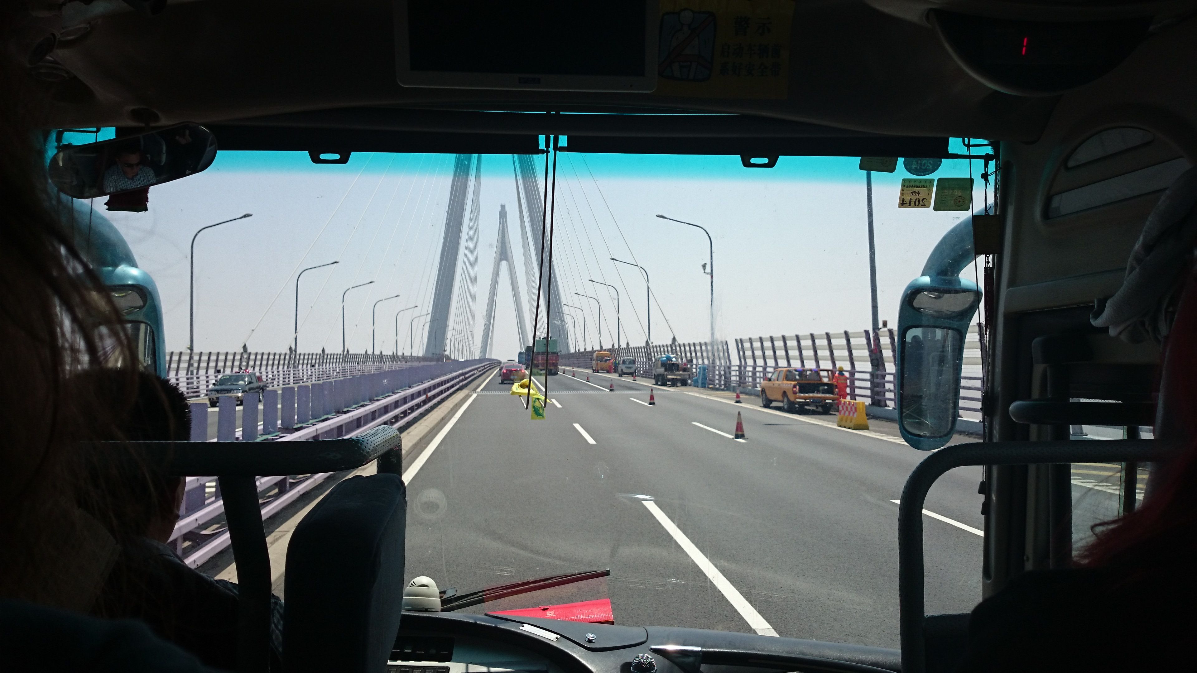 Ett foto taget framåt inifrån en buss. Bussen kör på en bro.