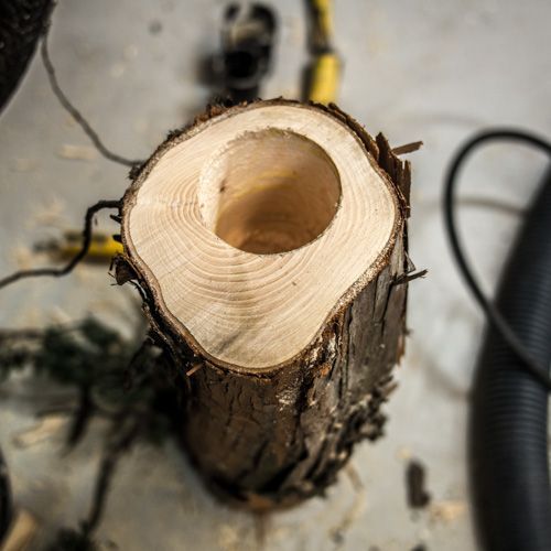 En träbit med ett tjockt borrat hål i