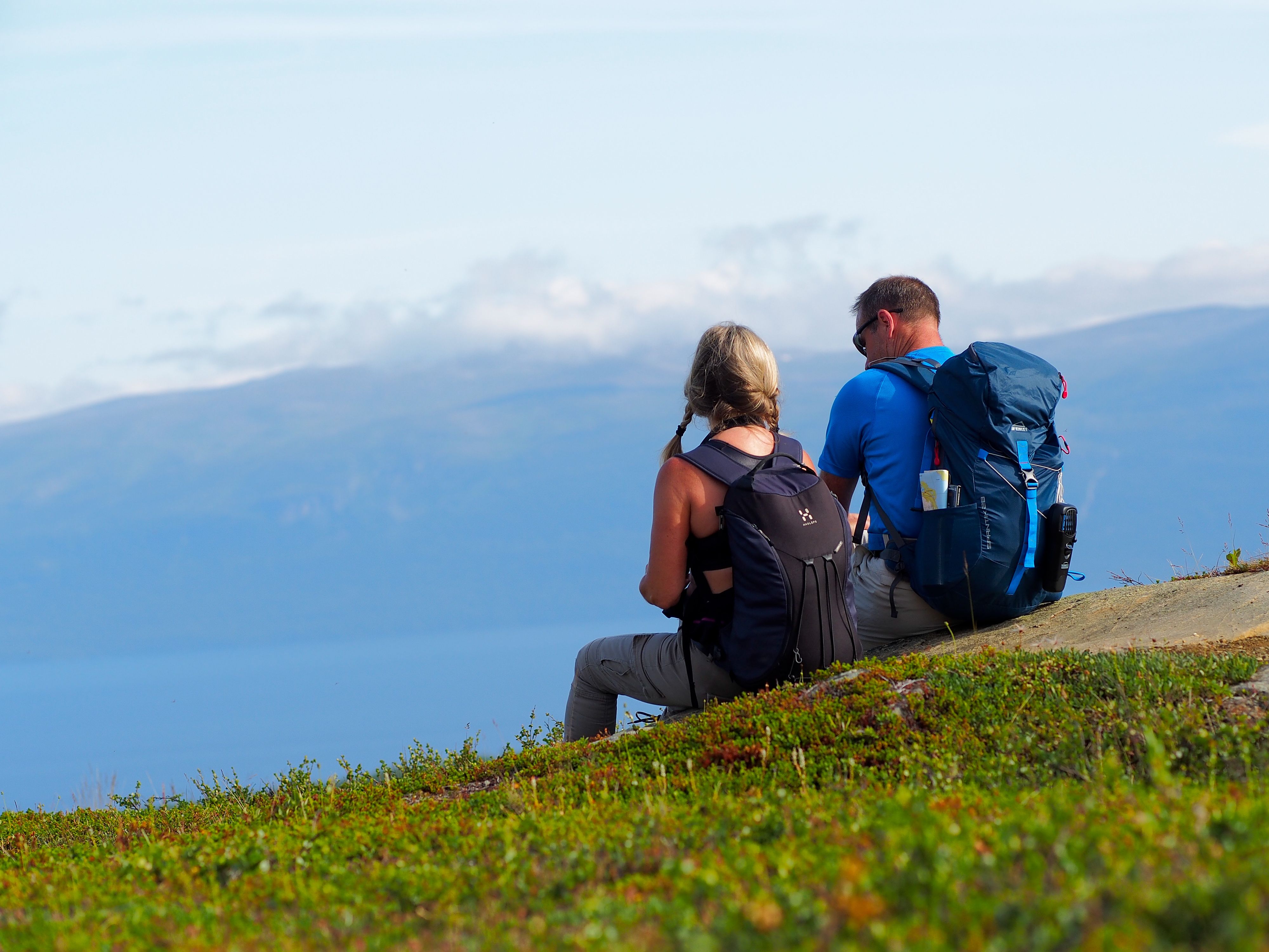 Två personer som sitter och tittar ut på utsikten från en höjd