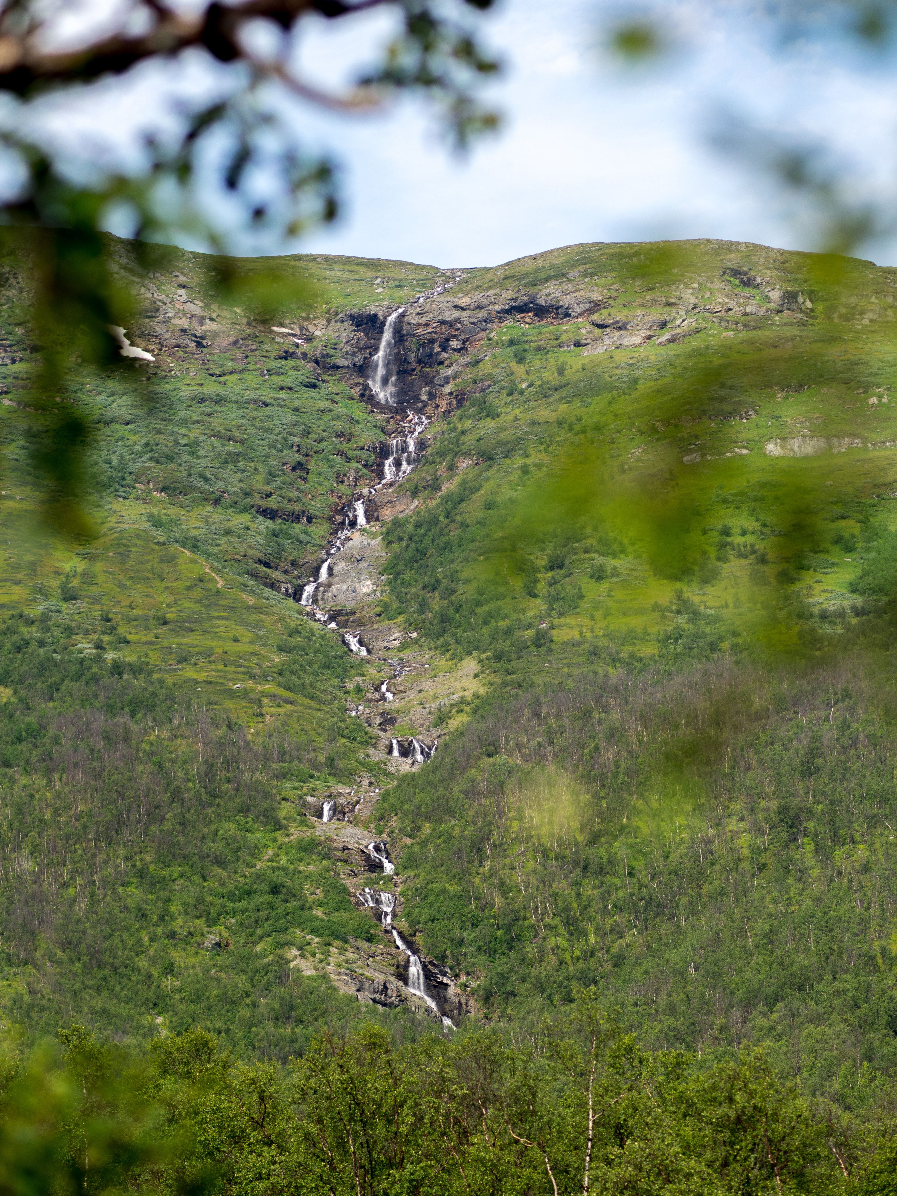 En bäck som rinner ner från berget Slåttajåkka i fjärran