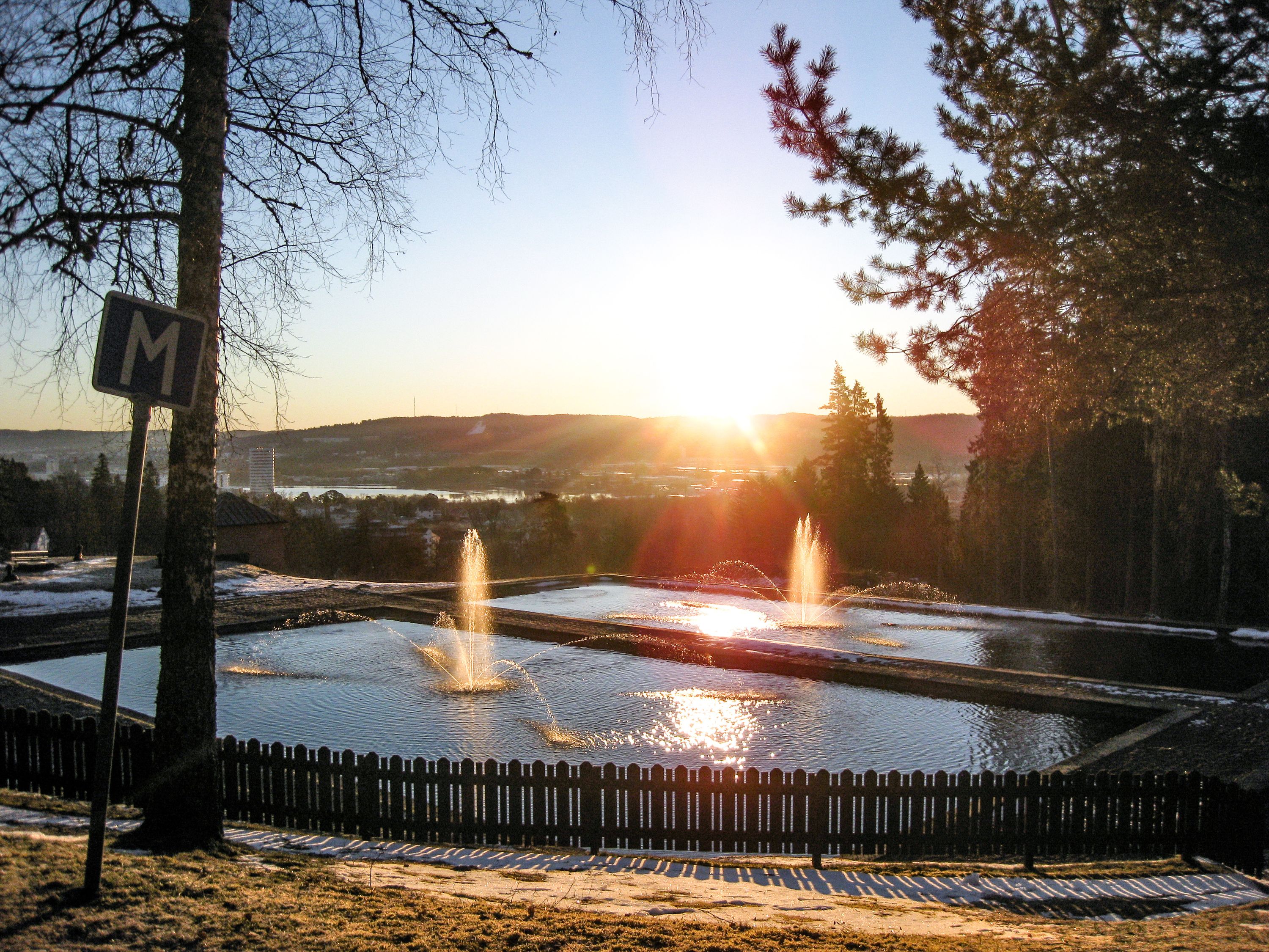 Två fontäner som är upplysta av morgonsolen