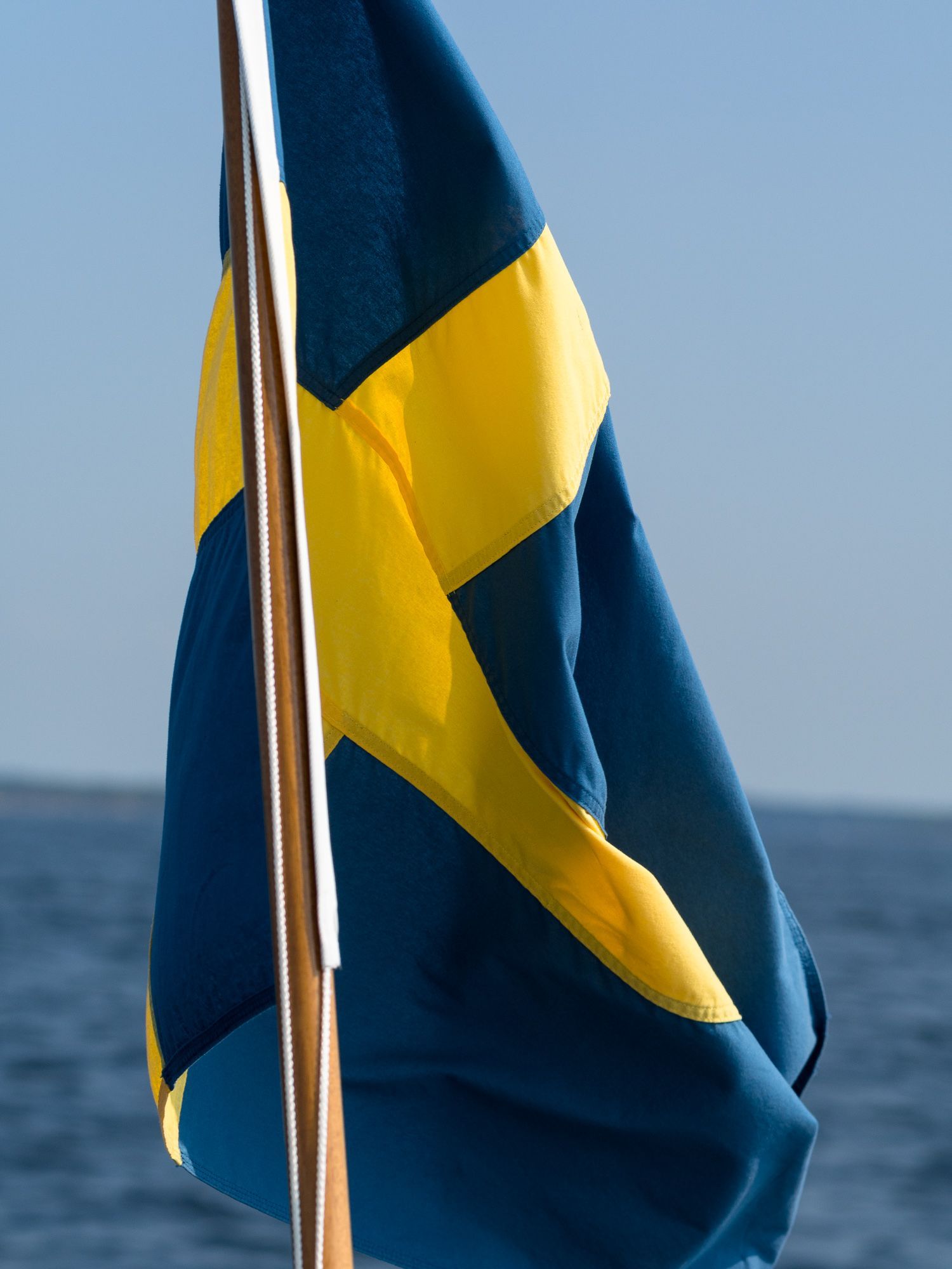 En hissad svensk flagg i aktern på en båt