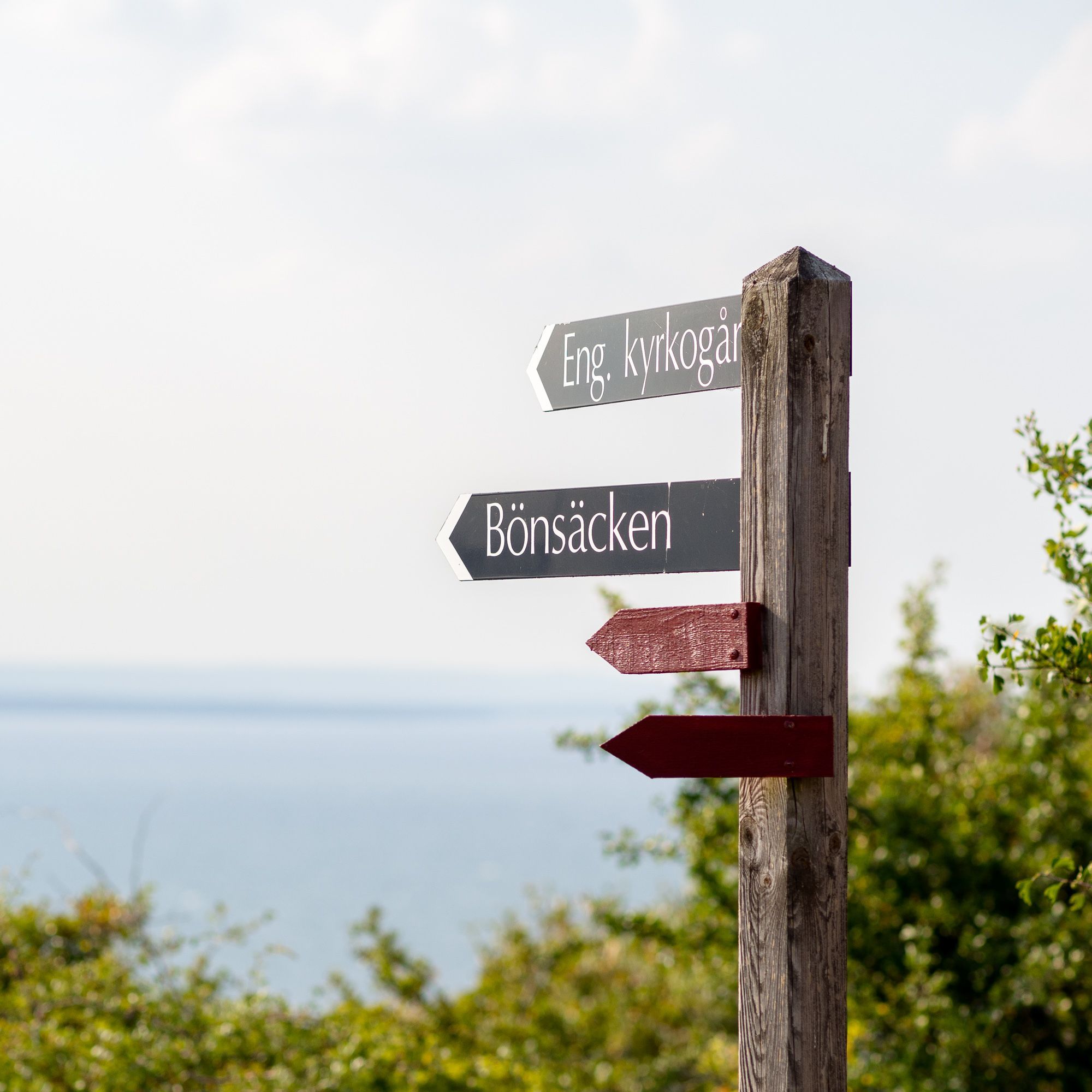 En skylt med en massa pilar. Två pilar syns med texterna: Engelska kyrkogården och Bönsäcken