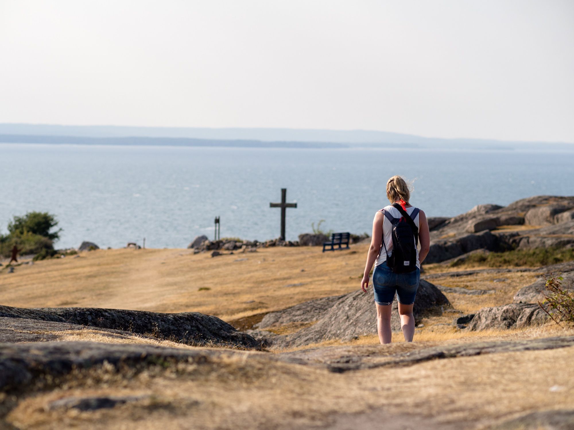 Josefine går ned mot en kyrkogård på den norra delen av Hanö. På kyrkogården syns ett stort kors.