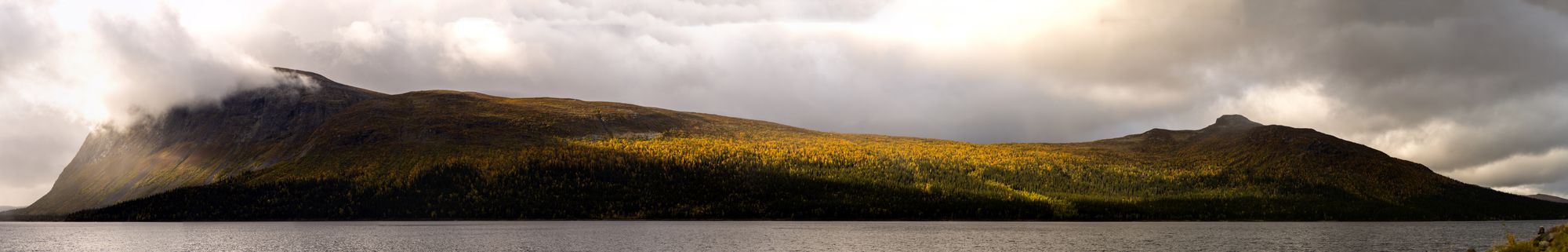 Borgajällan med moln över som delvis skuggar berget som i övrigt är kraftigt belyst av solljus