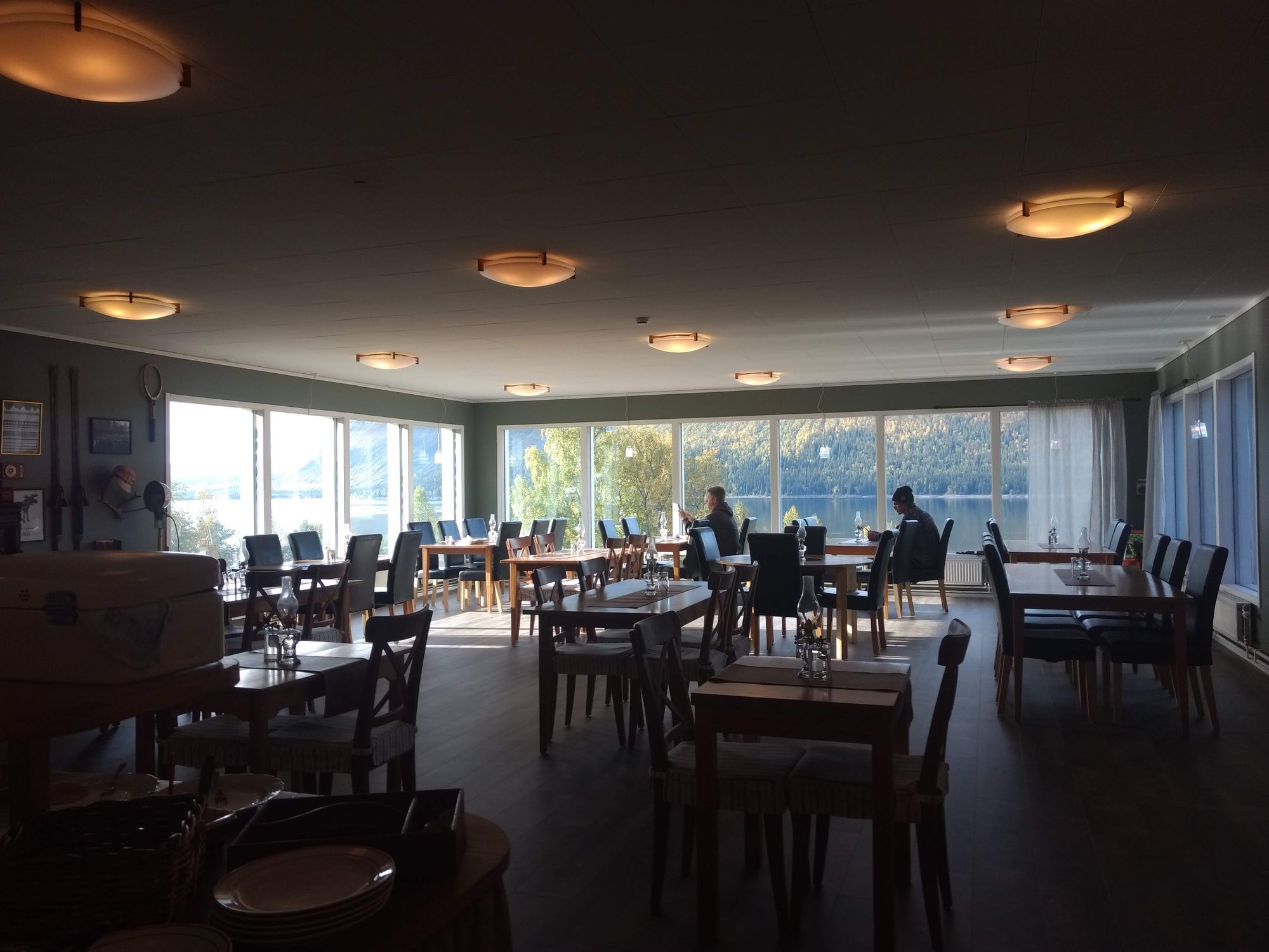 En matsal med en massa bord och stolar med utsikt över Borgafjäll och sjön