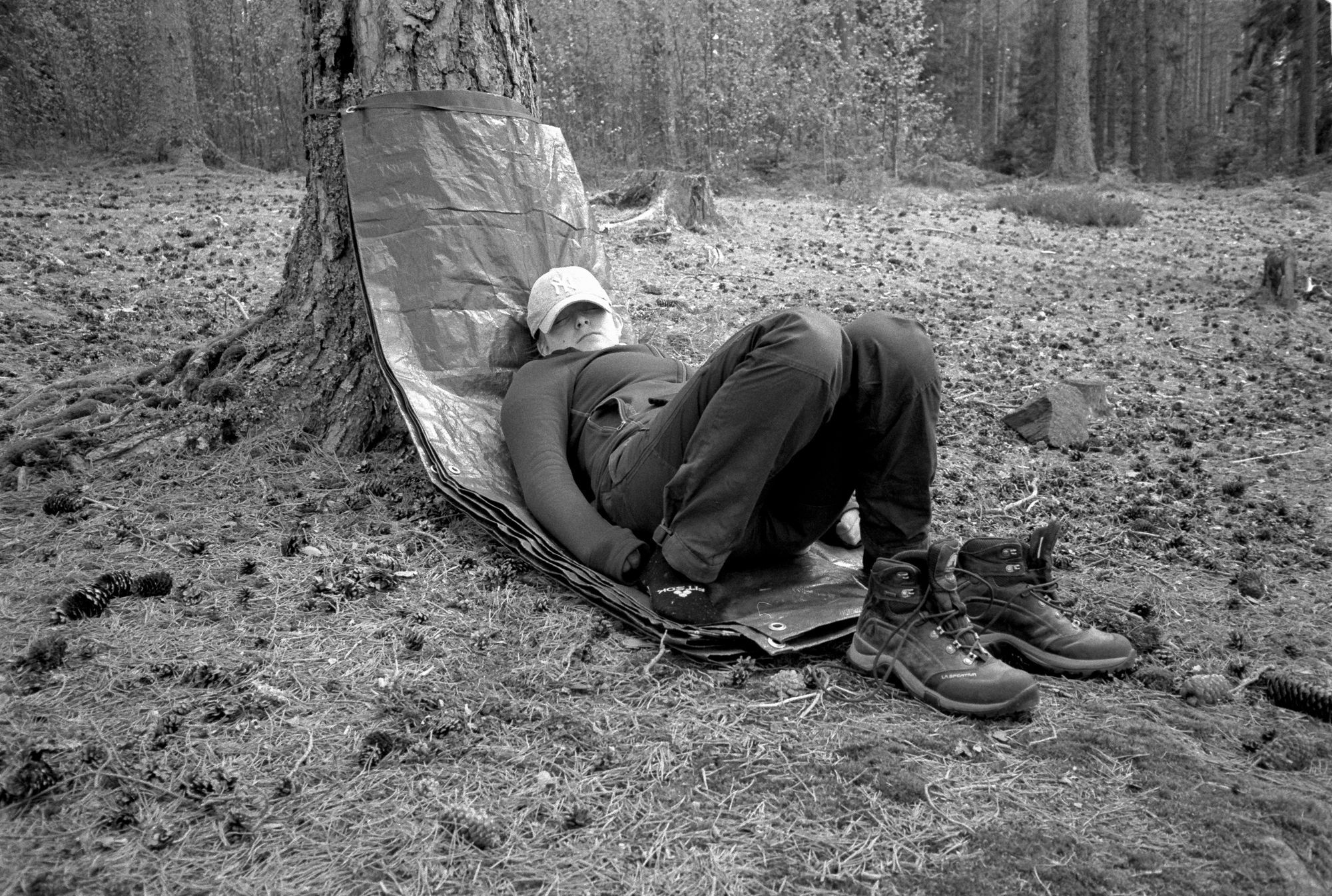 Josefine sover på en presenning mot ett träd