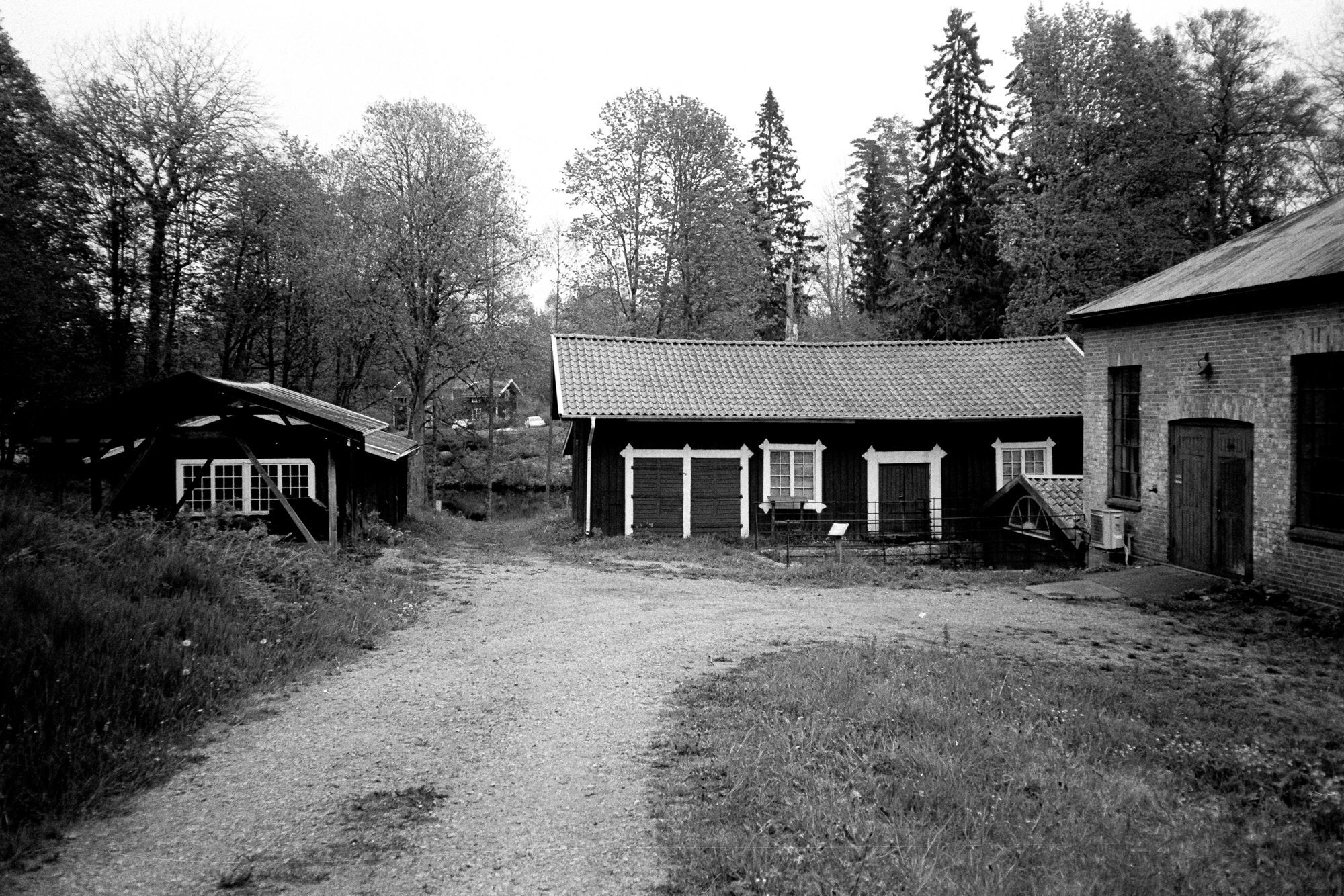 Två träbyggnader och en tegelbyggnad