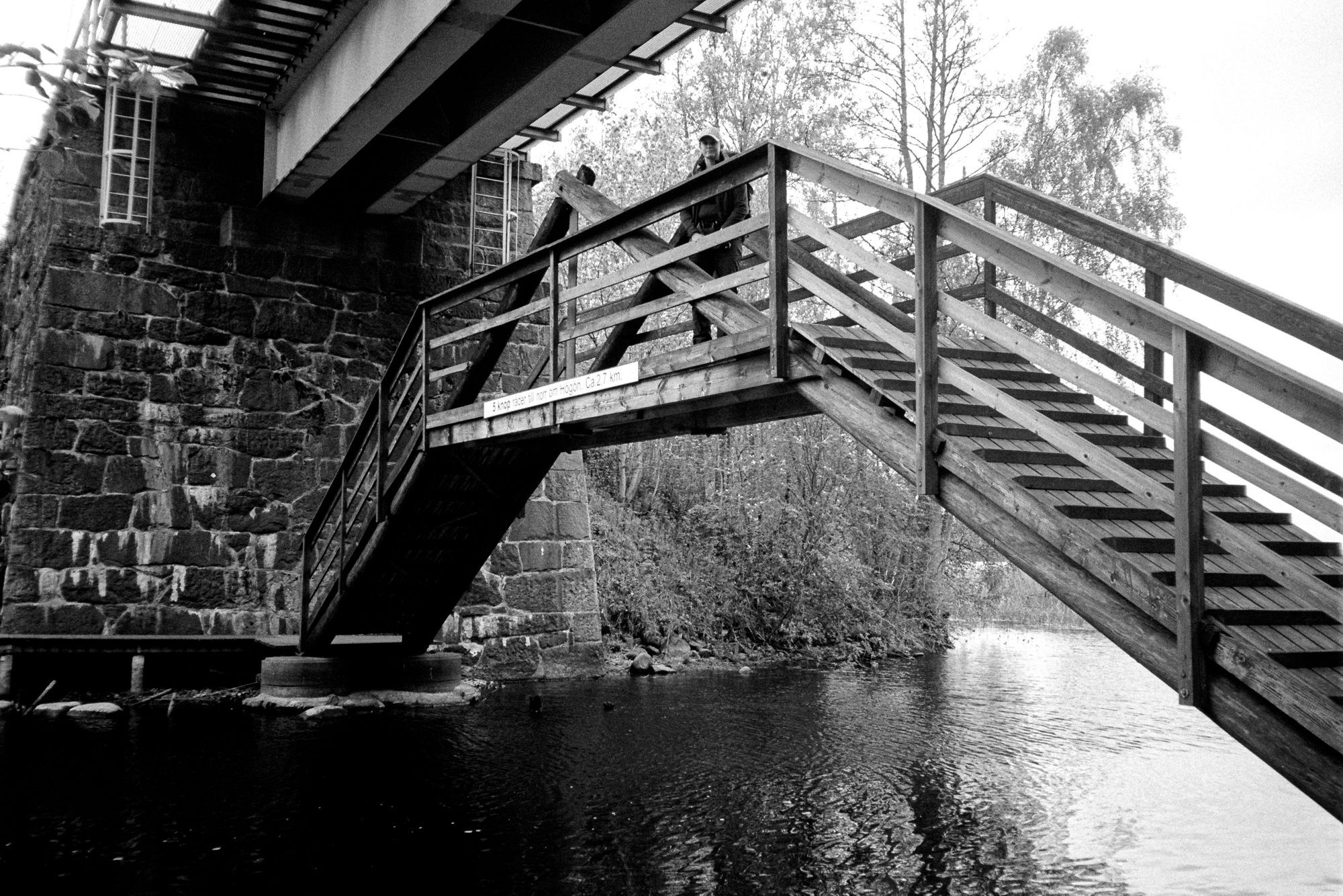 En träbro under en järnvägsbro.