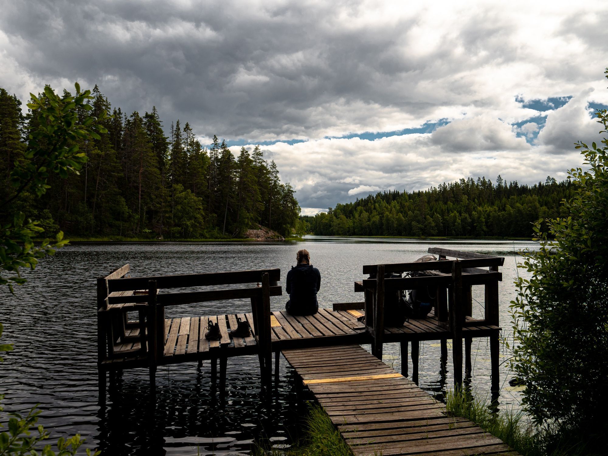 Josefine sitter på en brygga vid Pukasjön