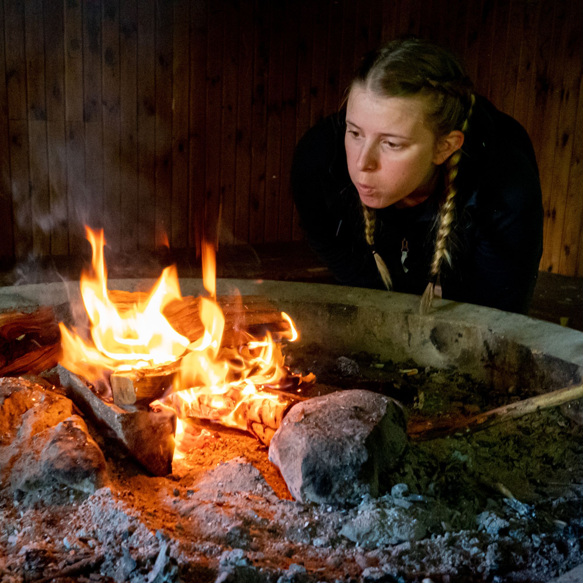 Josefine blåser på en eld