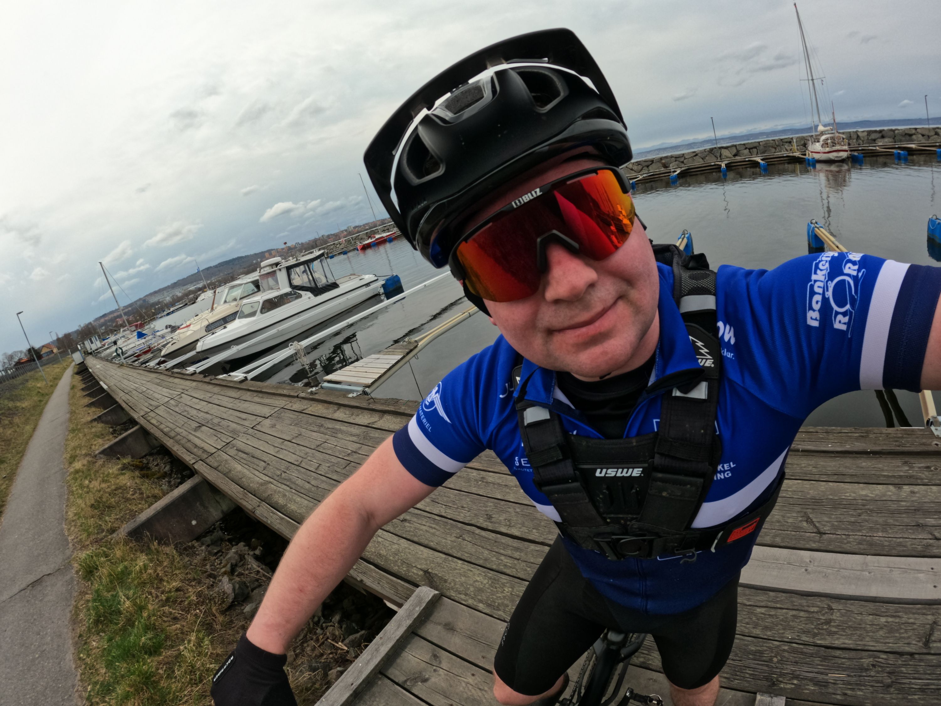 Selfie på Gustav på en cykel i MTB-kläder vid en hamn
