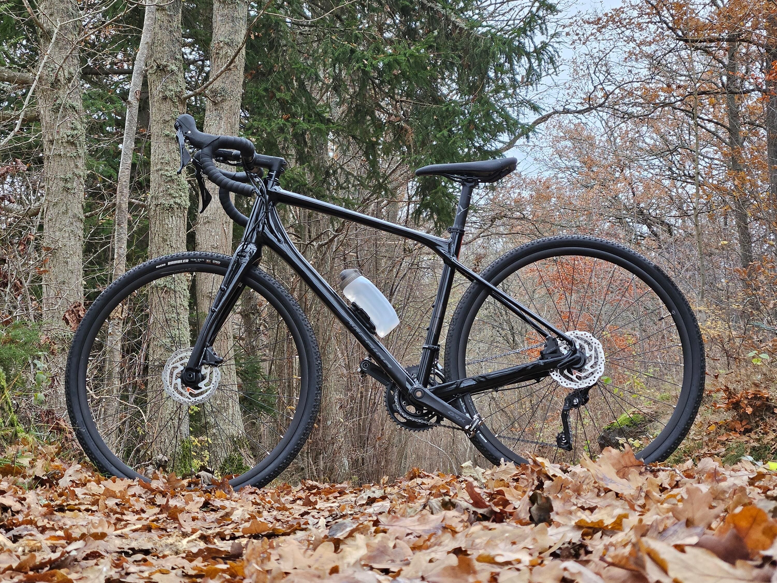 En svart gruscykel av modellen Merida Silex som står i profil på en väg