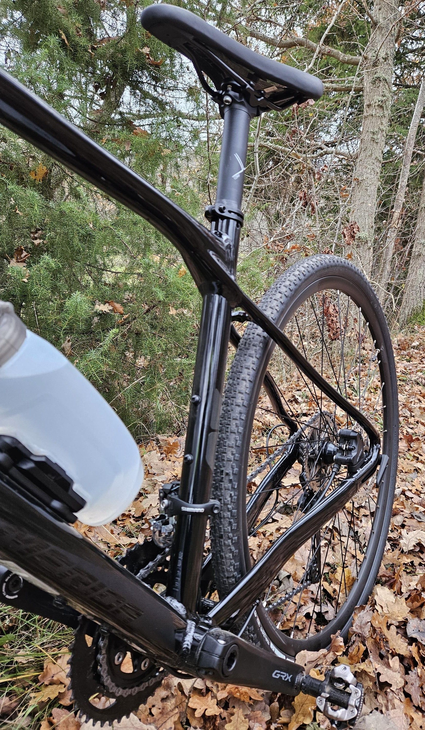 Bakhjulet och sittstolpen på en svart gruscykel sett bakifrån från sidan.