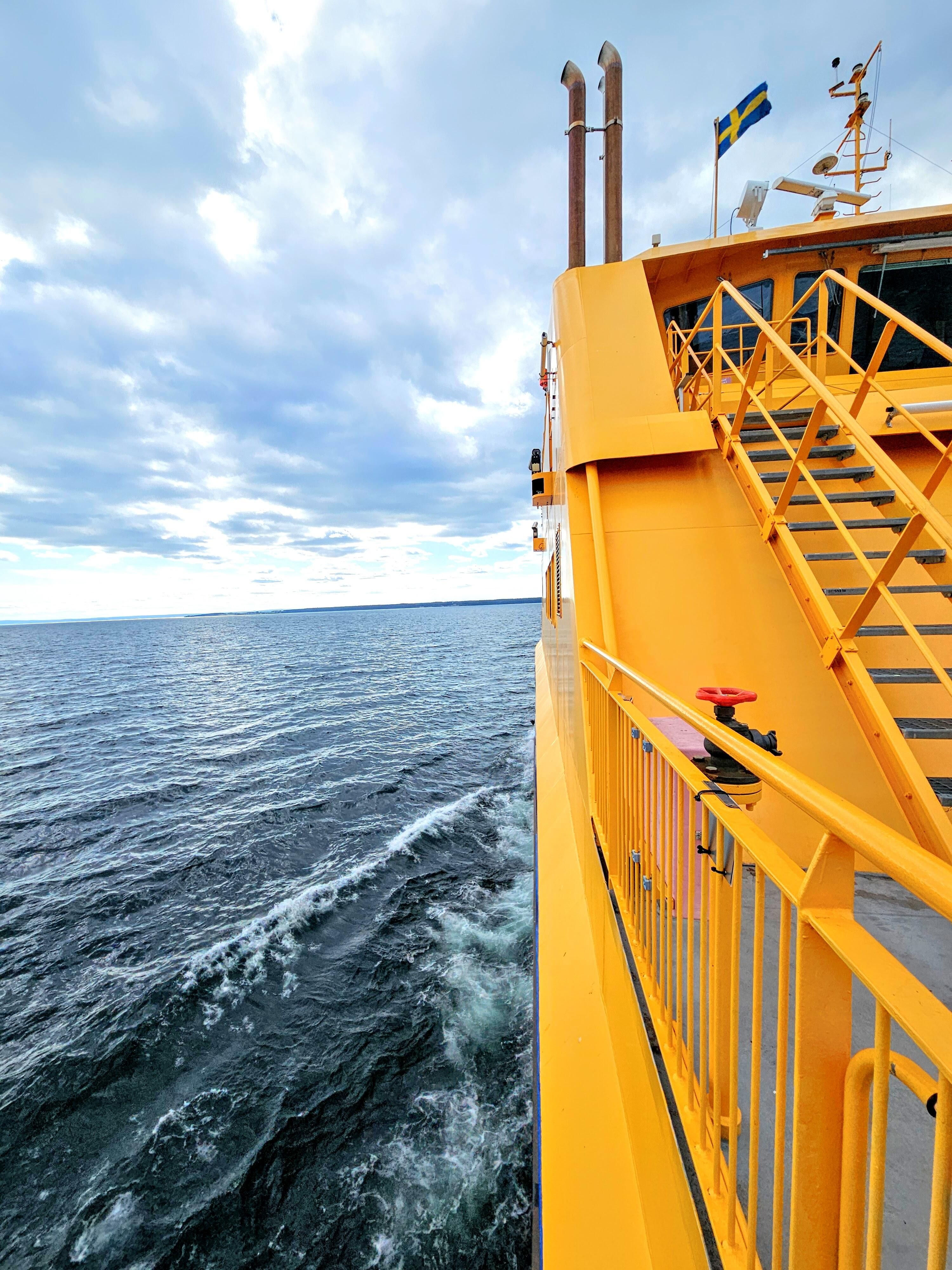 En gul färja. Bilden är tagen rakt fram längs sidan på båten.