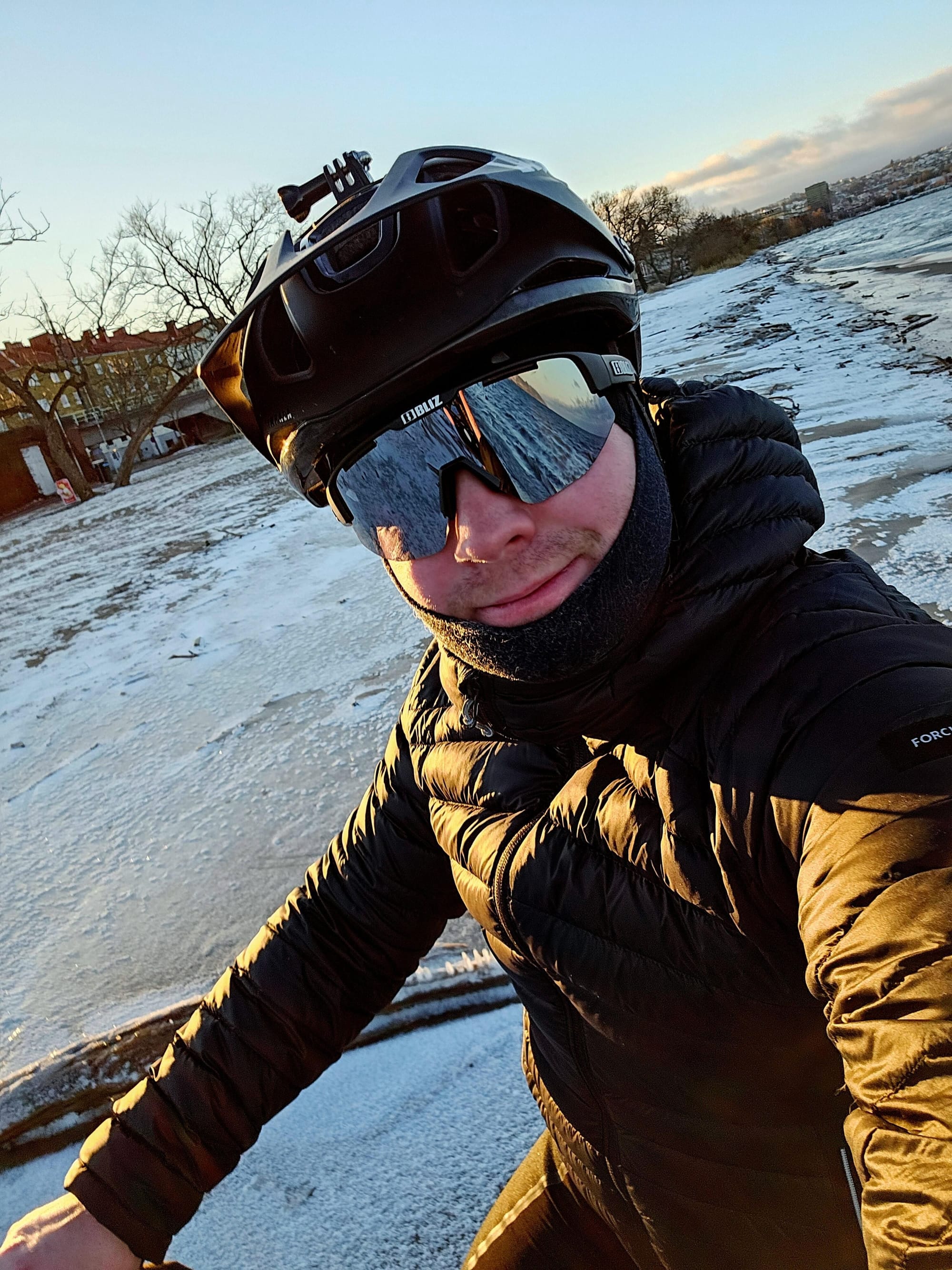 Selfie på Gustav iklädd dunjacka på en cykel på en istäckt strand