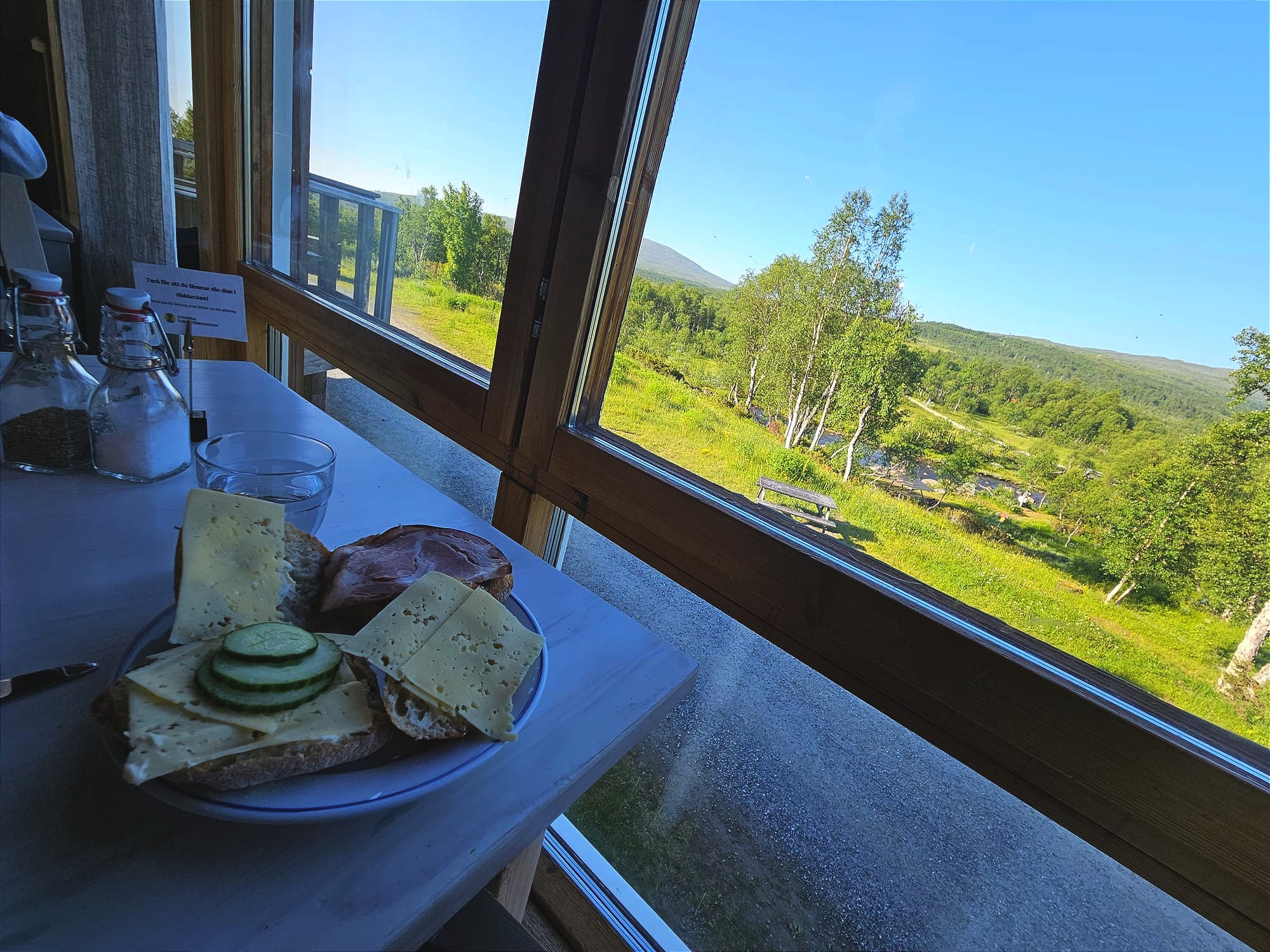 Ett bord med en tallrik med frallor. Bordet är intill ett fönster med utsikt över fjällen