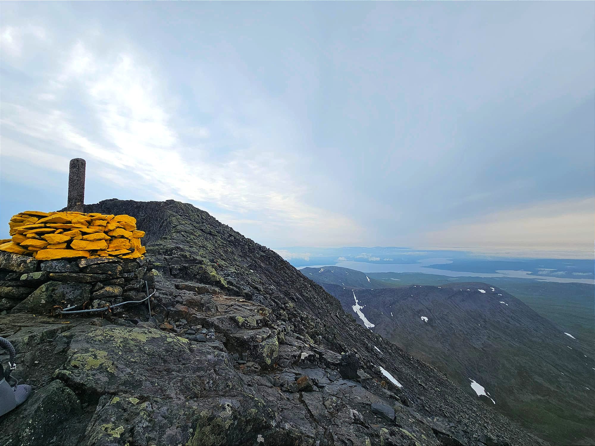 Ett gulmålat stenröse på en bergstopp