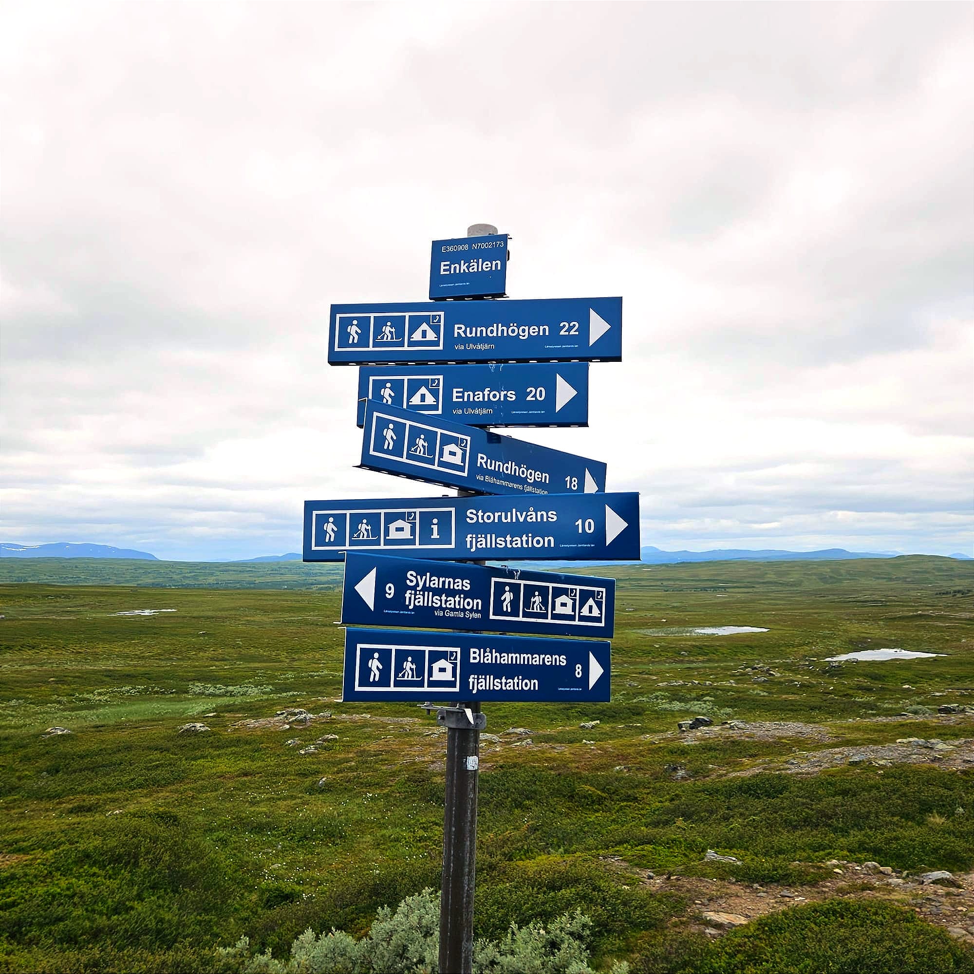 En skylt med pilar som pekar i olika riktningar mot olika fjällstationer och andra mål