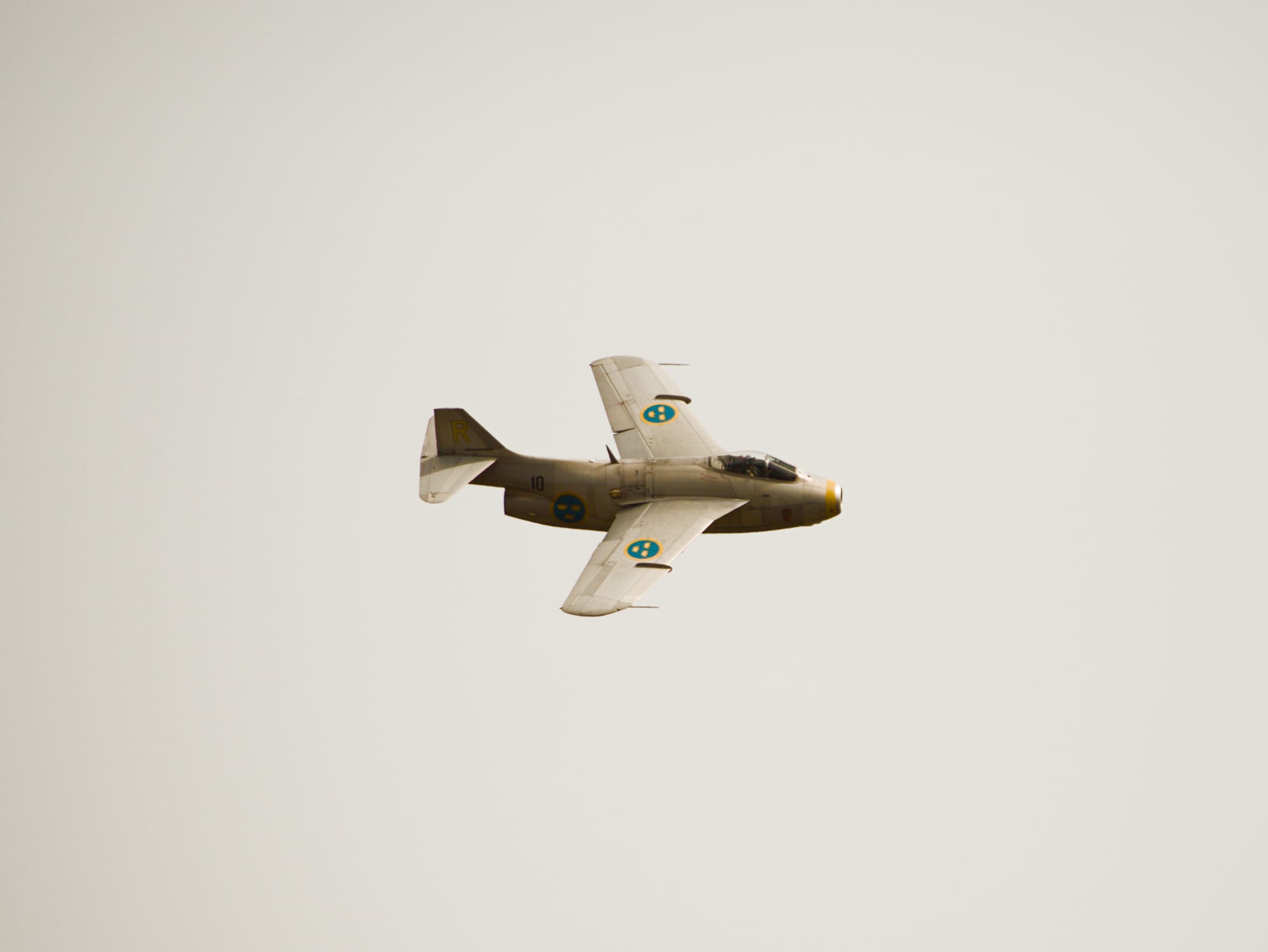 Ett stridsflygplan med en tjock kropp och bakåtvinklade pilvingar. På vingarna syns skölden för det svenska flygvapnet med tre kronor.
