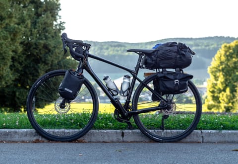 En fullastad cykel med väskor på framgaffeln och bak på pakethållaren.